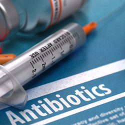 Syringe and needles next to antibiotics
