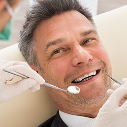 man in suit getting dental checkup