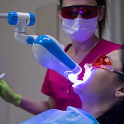 woman getting zoom teeth whitening from cosmetic dentist