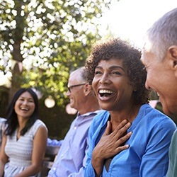 Woman laughing with group of friends outdoors