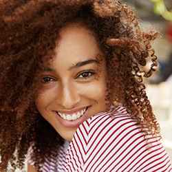 A young woman wearing a red and white striped shirt and smiling