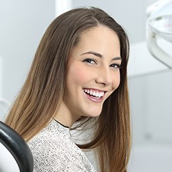 woman in grey shirt smiling bright