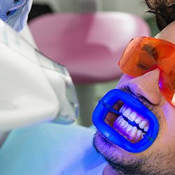 man getting teeth whitening in dental office
