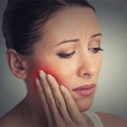 Woman holding her cheek in pain