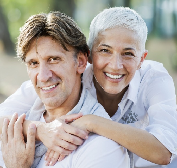 Senior woman hugging man from behind