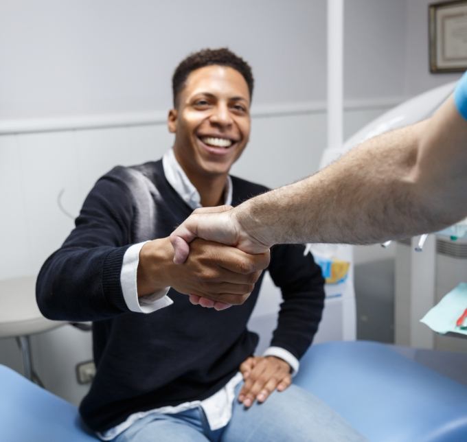 Male dental patient shaking dentists hand