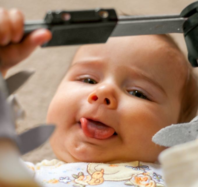 Baby lying down and sticking out tongue