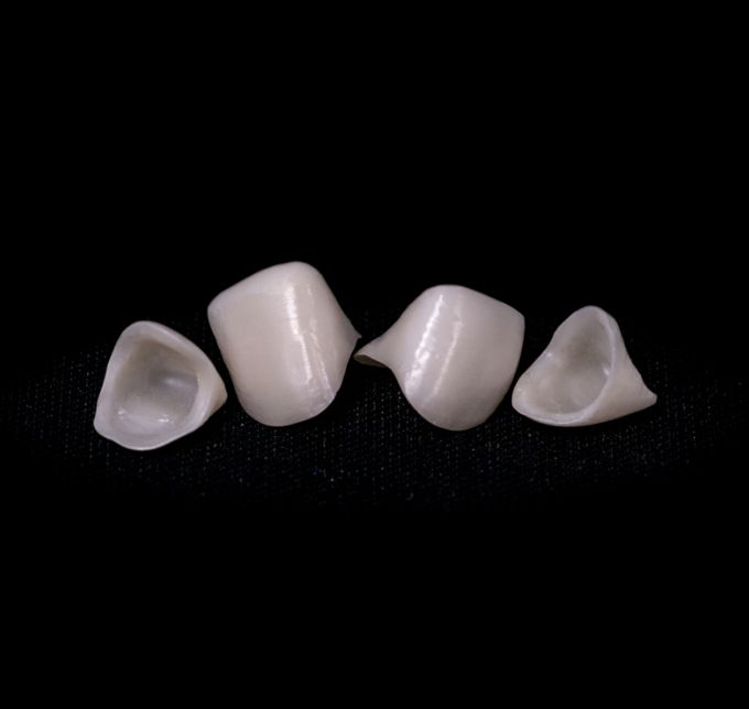 Four metal free crowns on black surface