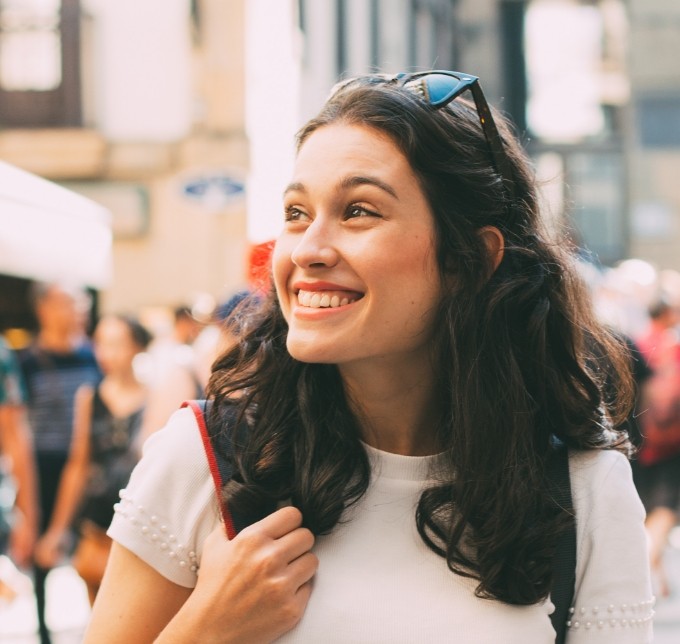 Woman in sweater walking down street and smiling
