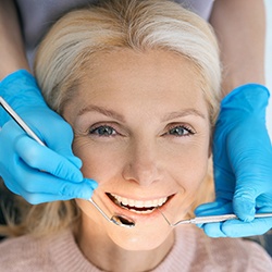 An older woman smiling after receiving a dental crown
