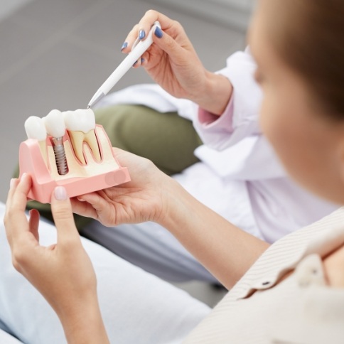 Showing a patient a model of a dental implant