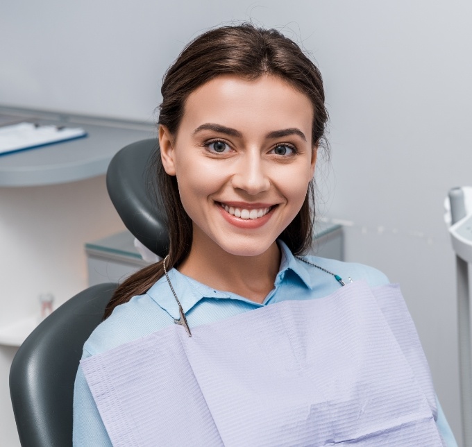 Woman sitting in dental chair and smiling