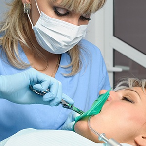 Dentist performing gum recontouring on a patient