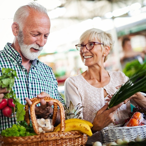 A man and woman smiling and shopping for healthy foods