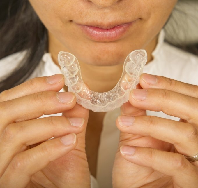Woman about to put in an Invisalign aligner