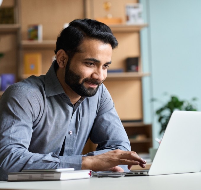 Bearded man working on a laptop