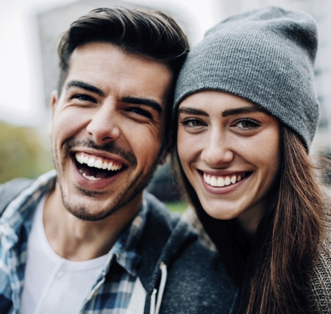 Man and woman leaning against each other and smiling