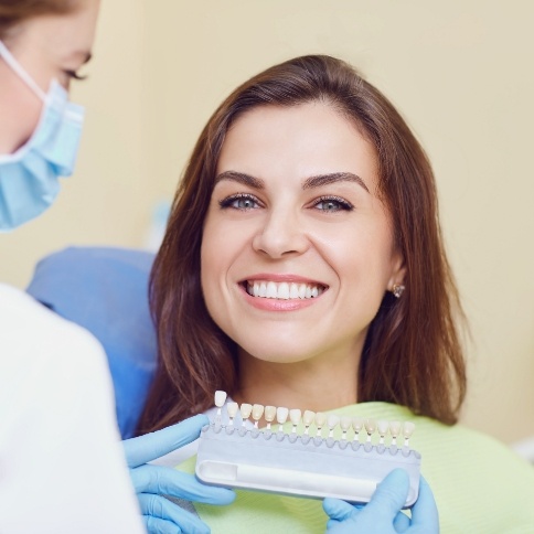 Female patient smiling at dentist during shade matching