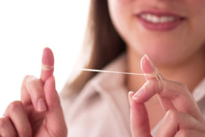 A woman with dental floss.