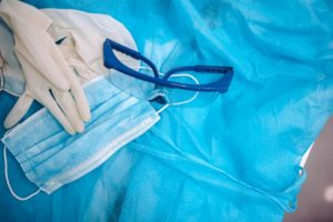 an image of gloves, protective eyewear, a facial mask, and a disposable gown