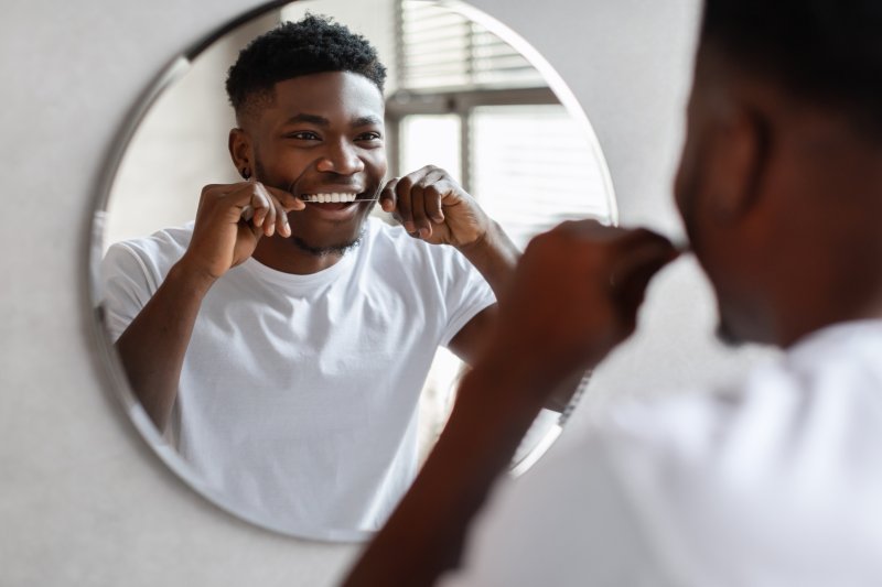 man flossing his teeth