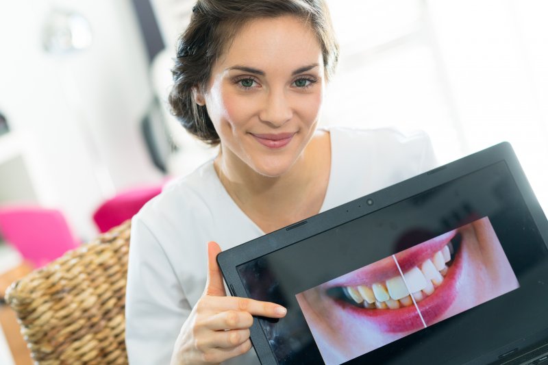 a cosmetic dentist holding a photo of patient’s smile